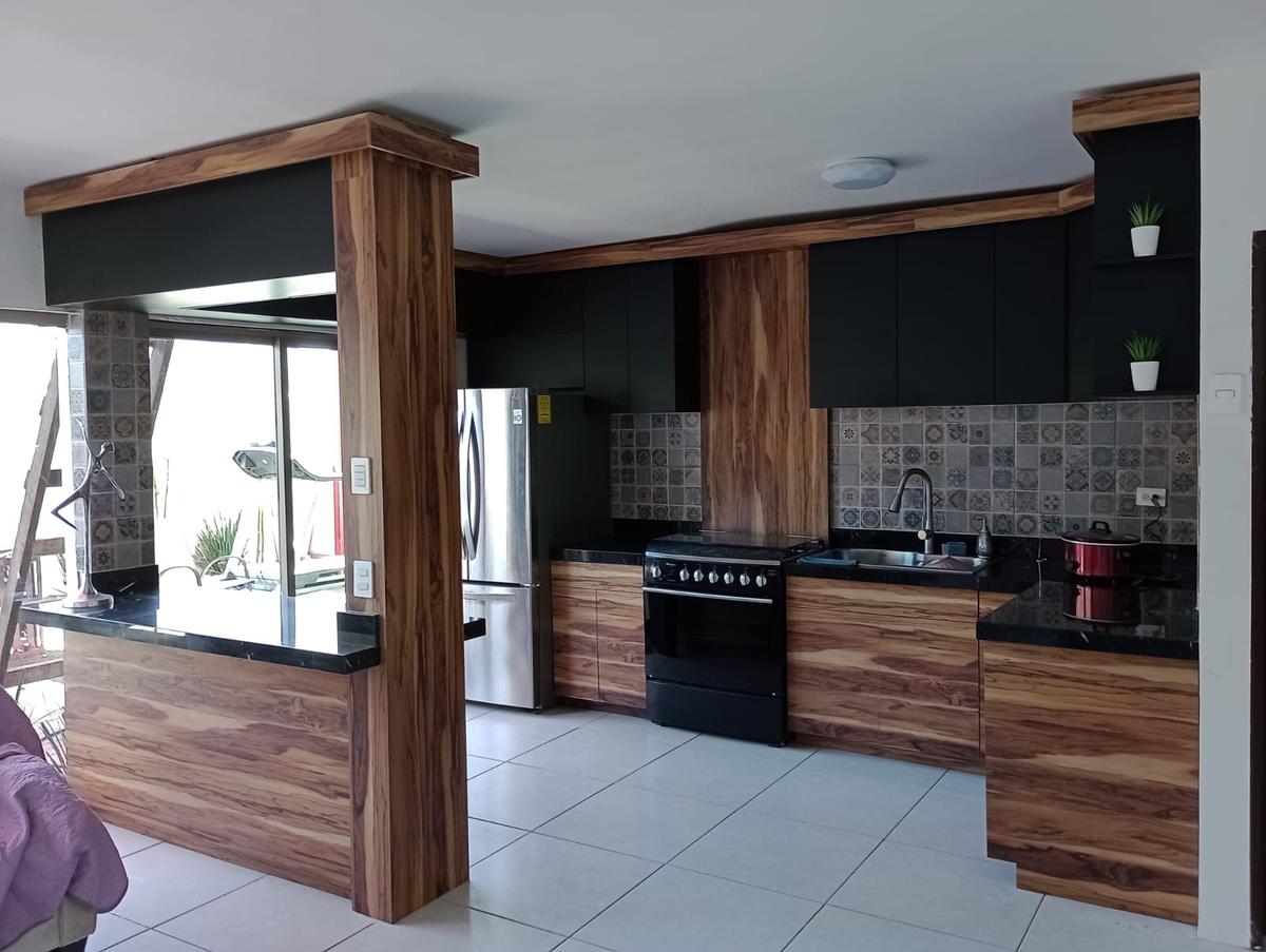 Cocina nogal con gabinetes negros y granito