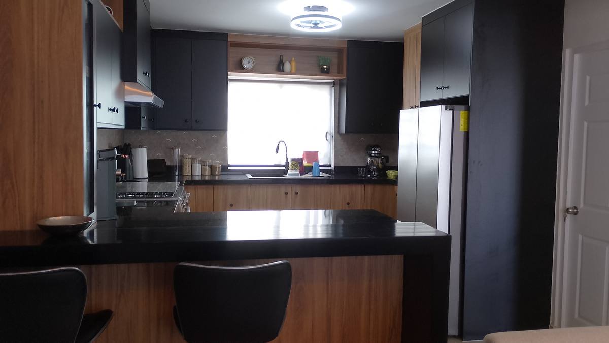Cocina negro y madera con barra y granito