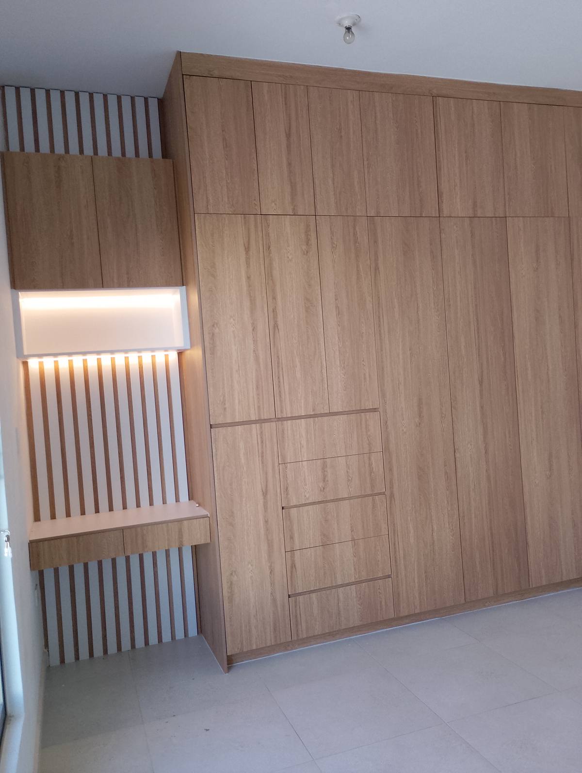 Closet roble con panel decorativo ranurado e iluminación LED