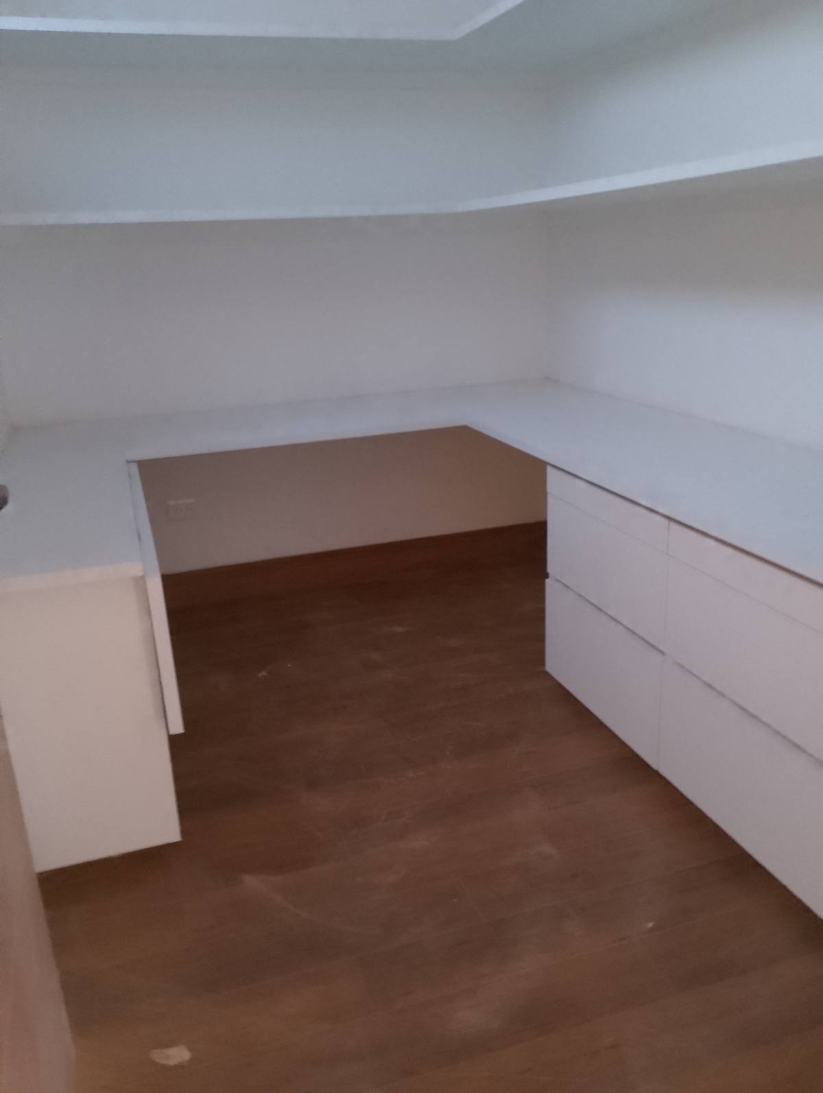 Vestidor blanco en L con cajones corridos y piso de madera
